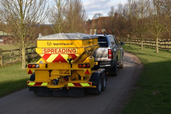 Pickup truck pulling a trailed gritter